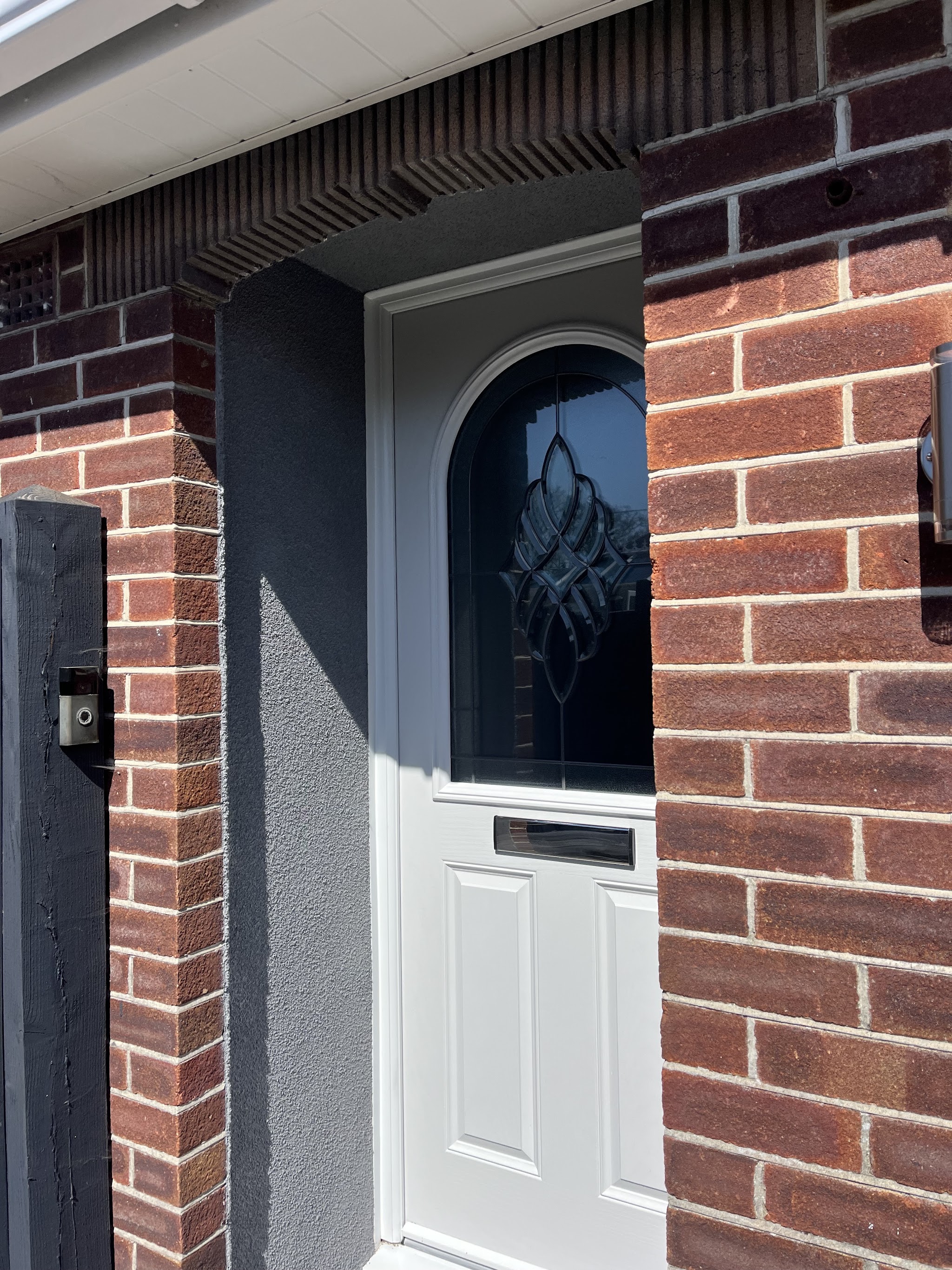 Close-up of a textured grey render reveal around a front door