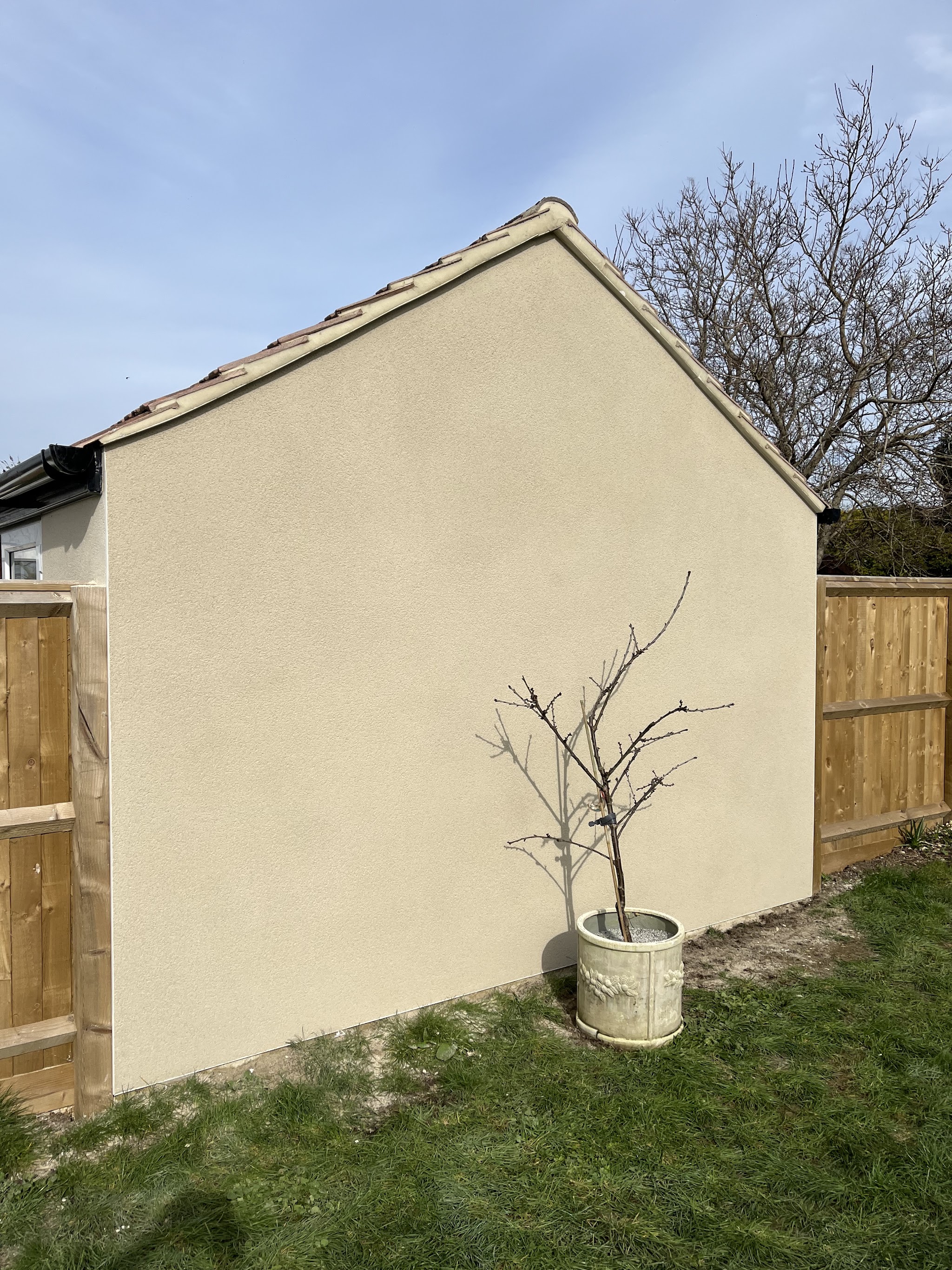 Gable wall of a garden building finished in cream render