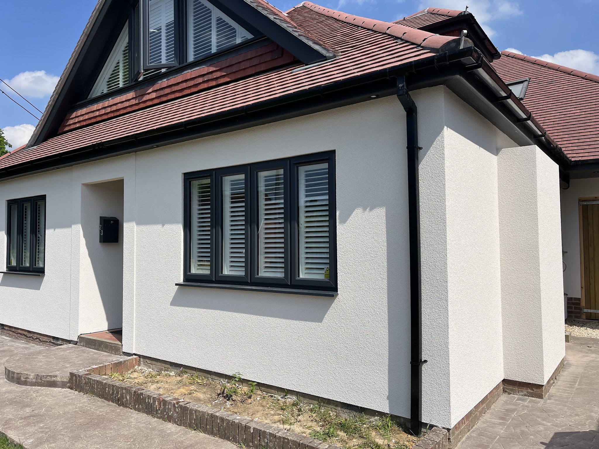 Chalet bungalow with a white through-coloured render finish