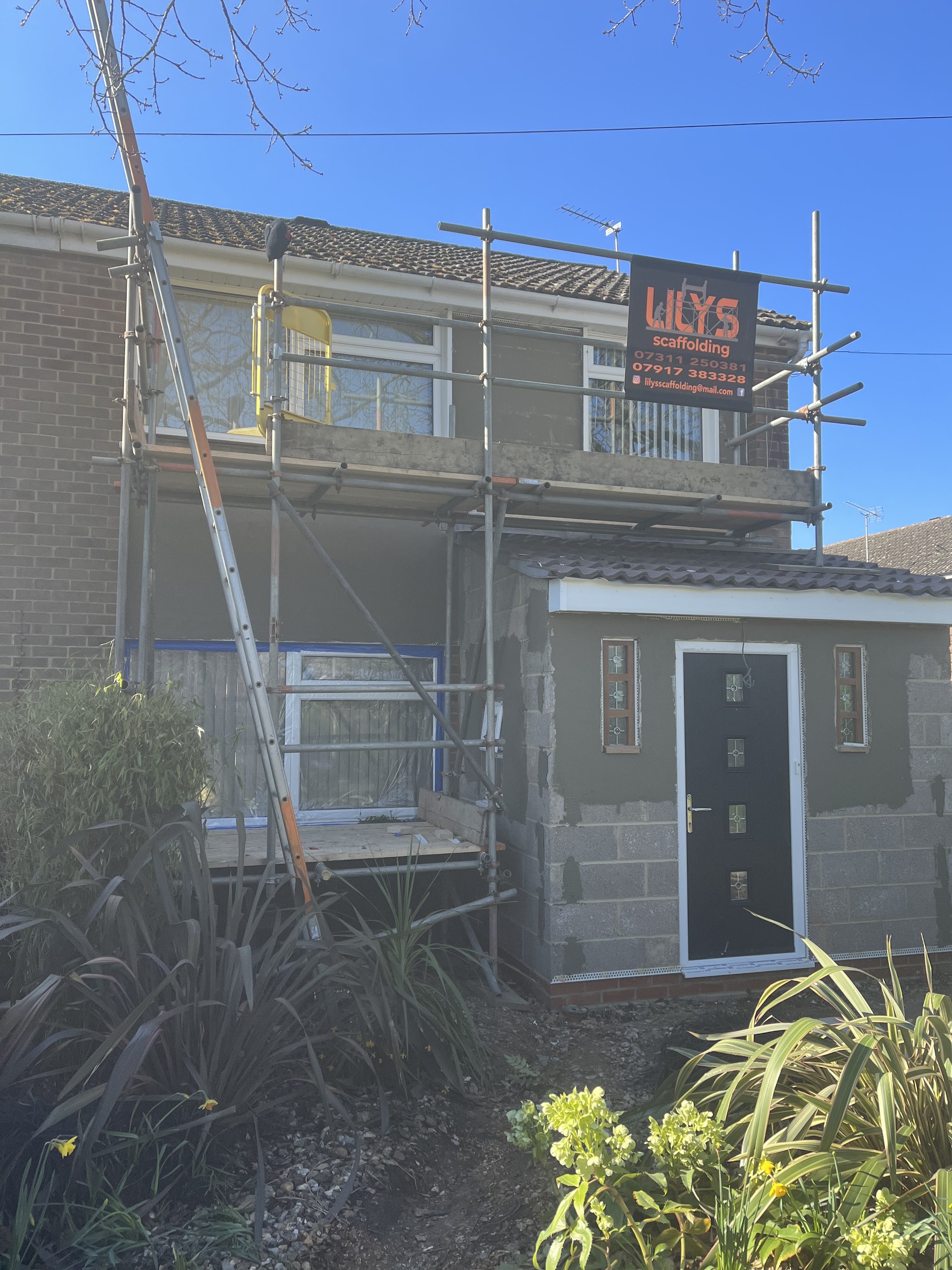 House front under scaffolding with blockwork prepared for render