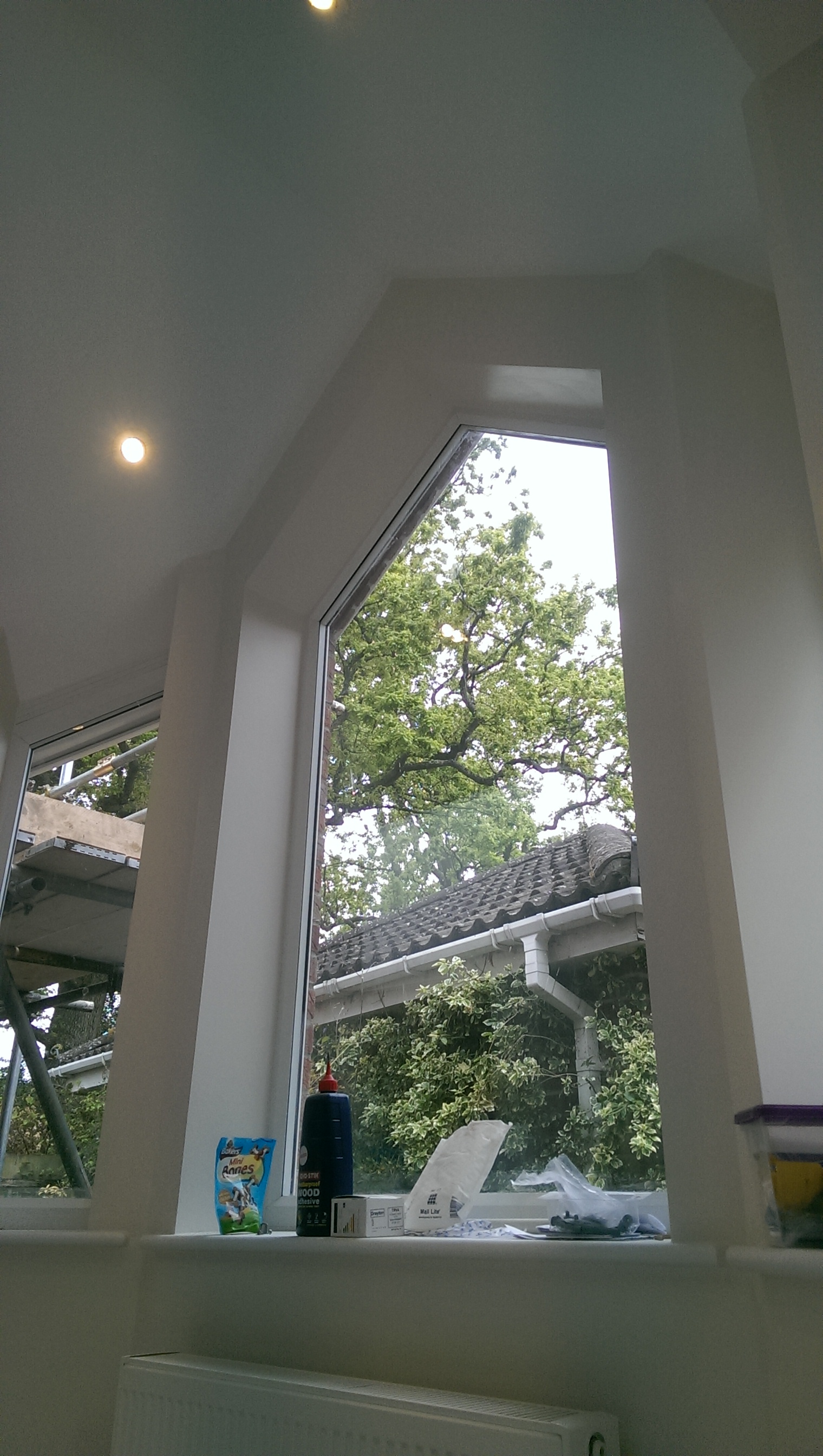 Double-height plastered interior with an angled window