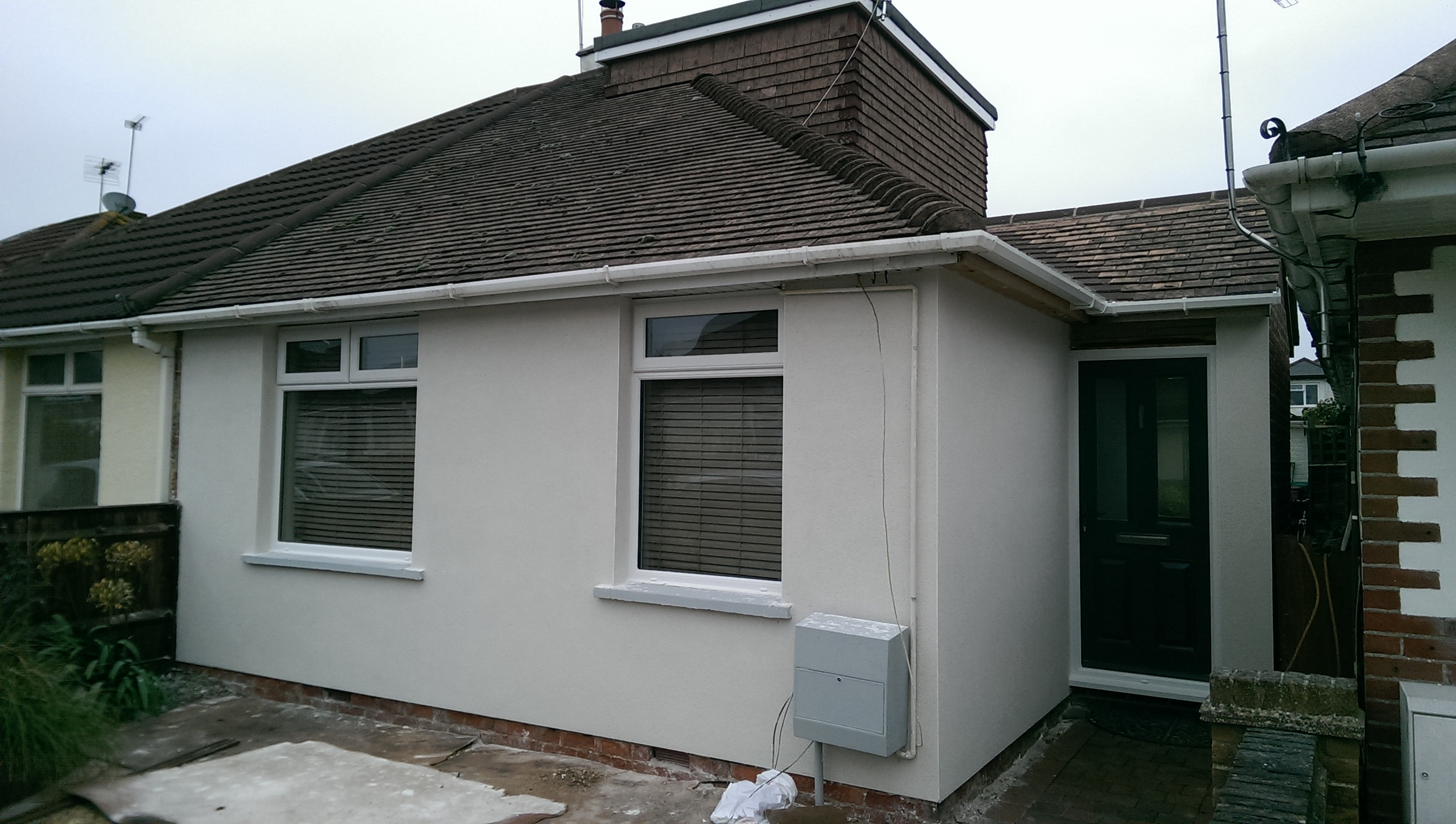 Bungalow side wall finished in off-white render