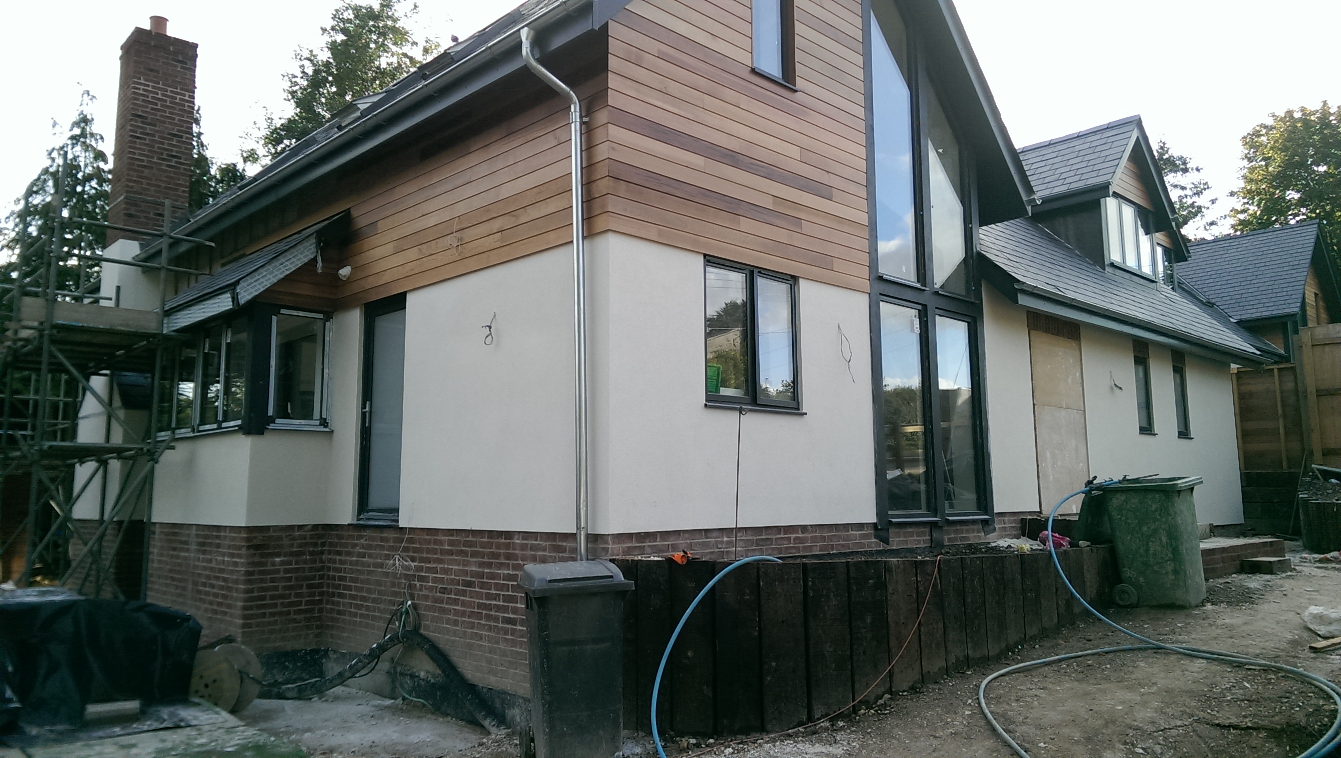 New-build house with cedar cladding and cream render